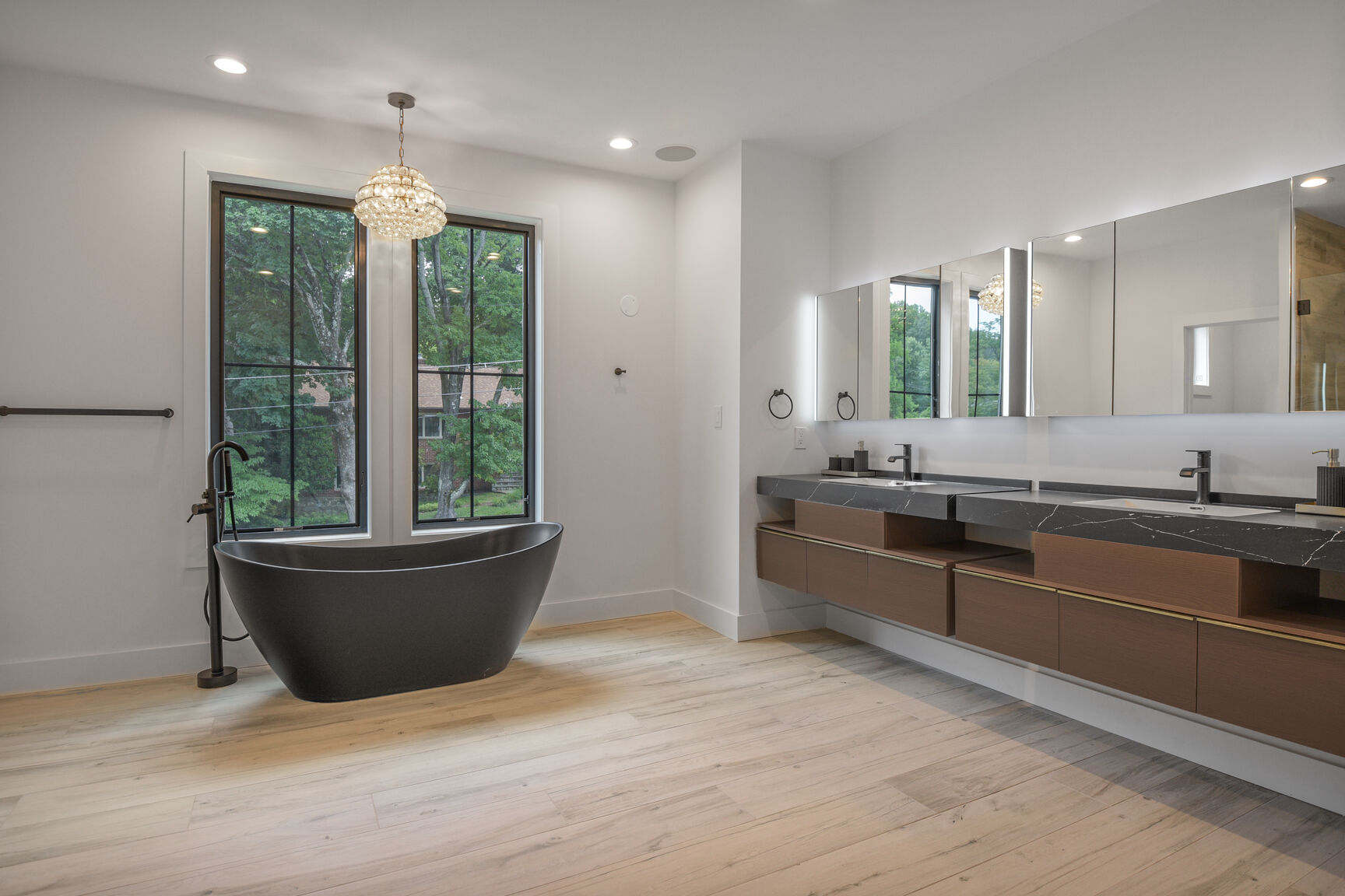 Master bath with black soaking tub and dual vanity